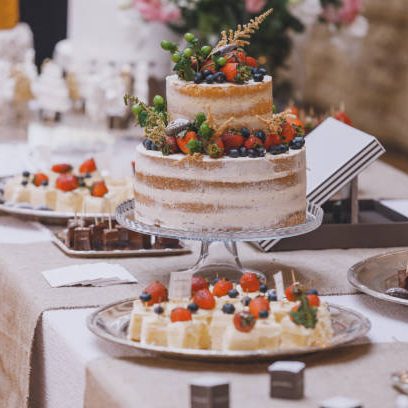 Elegant sweet table bar ornated variety of French patisserie baking in the banquet hall buffet with a variety of delicious sweets, colorful decorated big cakes, macaroons, fruits, candles, text signs, and pastries for weddings, Valentine's days, birthdays, Christmas, New Year's Eve, or another celebrate events on the table